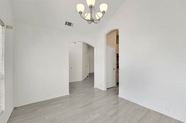 Tiled spare room with an inviting chandelier | Image 6