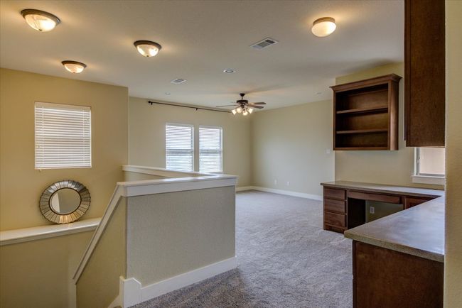 Gameroom featuring nice built-ins, ceiling fan, open shelves, and light colored carpet | Image 23