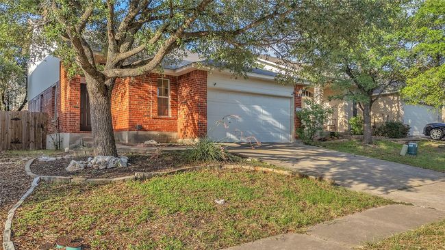 View of front facade featuring brick siding, an attached garage, and driveway | Image 31