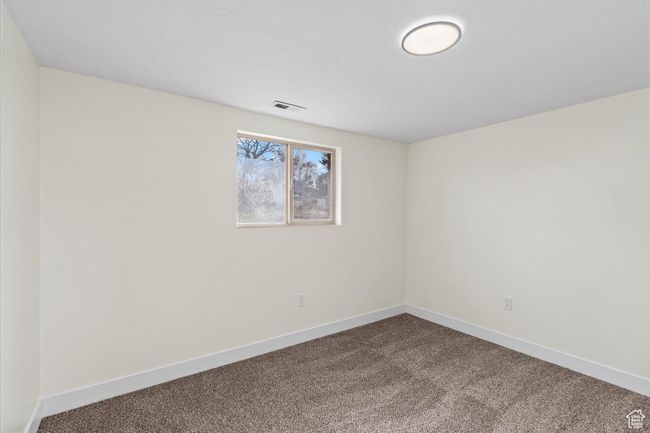 Spare room with baseboards, visible vents, and dark colored carpet | Image 14