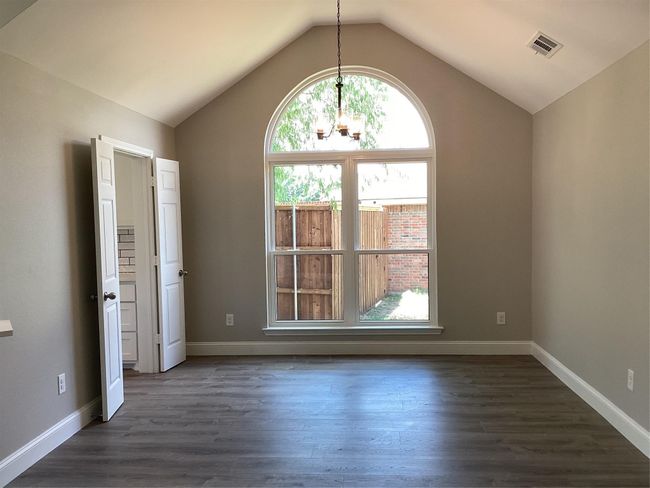 Unfurnished room with a chandelier, lofted ceiling, and dark wood finished floors | Image 7
