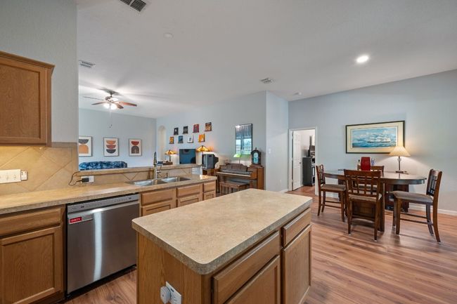 Kitchen featuring dishwasher, a sink, light wood-style flooring, and tasteful backsplash | Image 12
