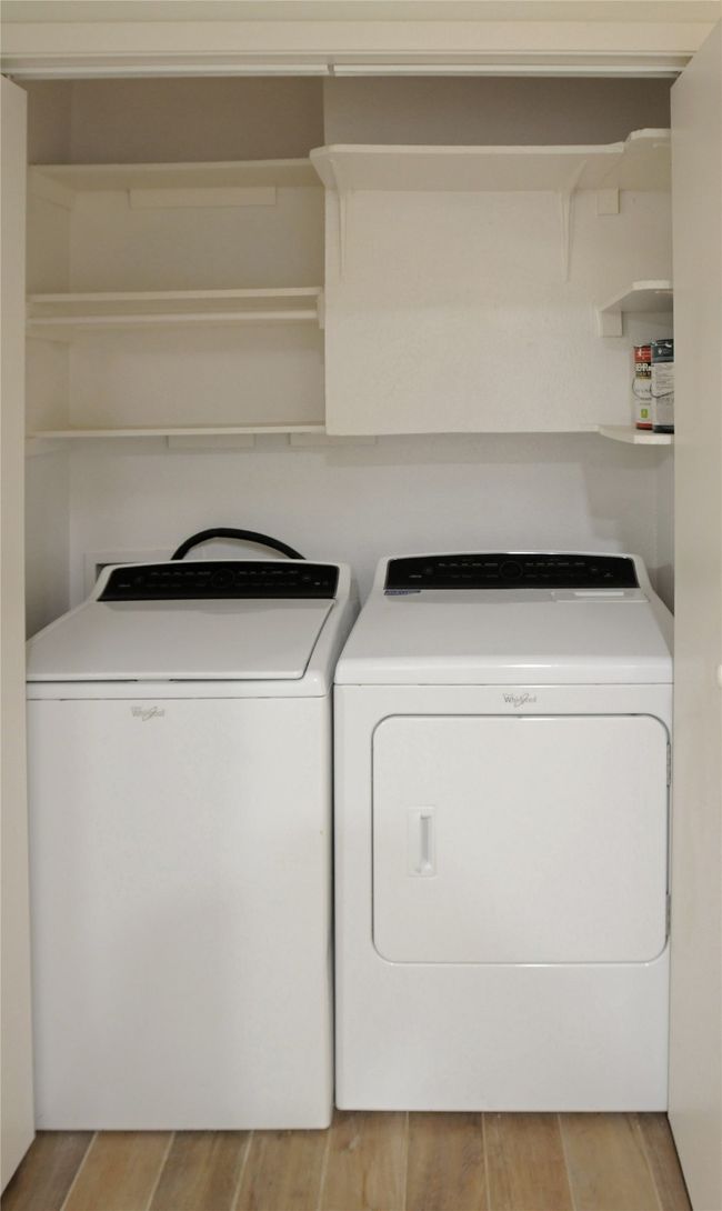 Clothes washing area with separate washer and dryer and Luxury Vinyl Plank flooring | Image 25