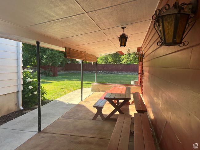 View of covered patio with included benches and table | Image 4