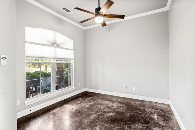 Empty room featuring finished concrete flooring, baseboards, ornamental molding, and a ceiling fan | Image 7