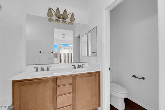 Full bathroom featuring double vanity, toilet, wood finished floors, and a sink | Image 12