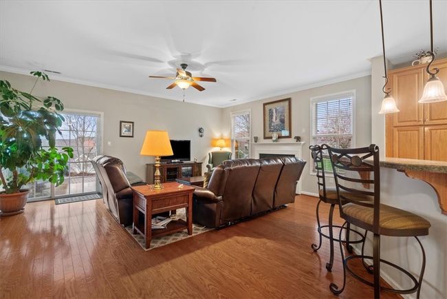 Hardwood floors flow throughout the entry and family room space. Notice the abundance of windows that filter in lots of natural light. | Image 9