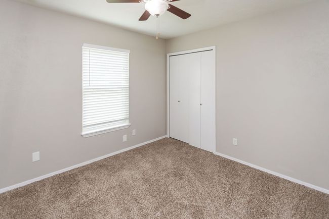 Unfurnished bedroom featuring carpet, a closet, and a ceiling fan | Image 28