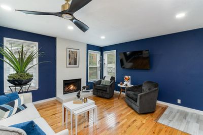 Living room with ceiling fan, wood-type flooring, plenty of natural light, and a fireplace | Image 3