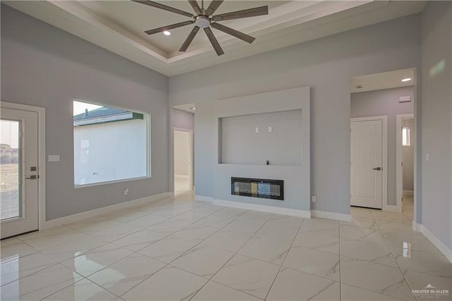 Unfurnished living room featuring ceiling fan | Image 7