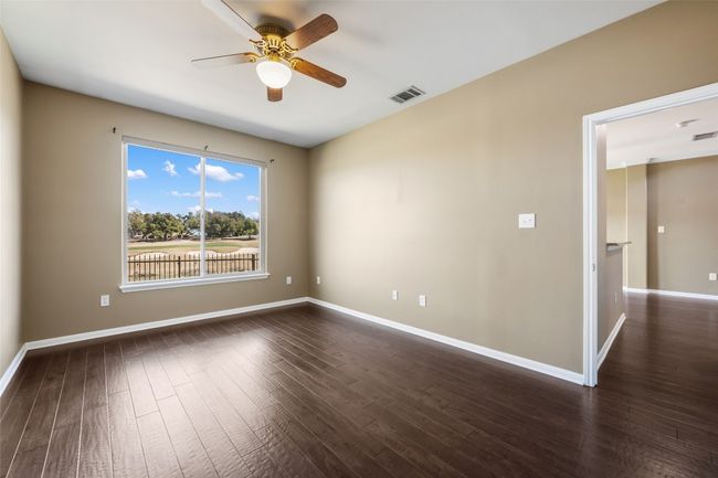 Primary bedroom with a ceiling fan, wood finished floors, and baseboards | Image 20