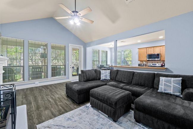 Living room with recessed lighting, a ceiling fan, high vaulted ceiling, and wood finished floors | Image 7