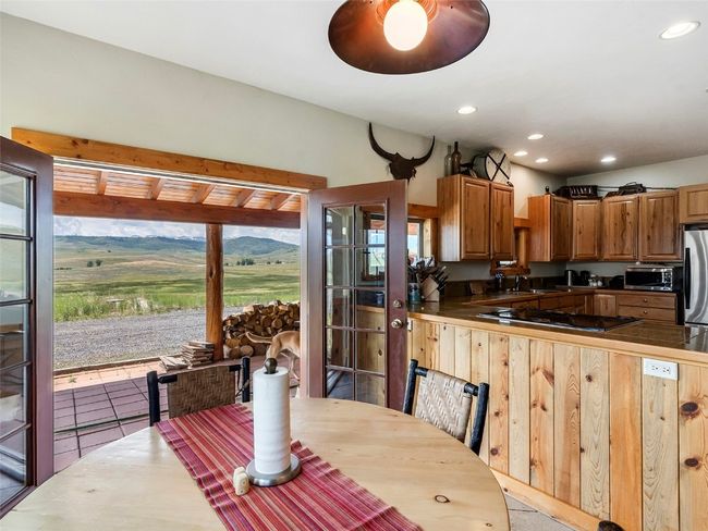 Kitchen with light tile patterned flooring, a mountain view, sink, appliances with stainless steel finishes, and kitchen peninsula | Image 24