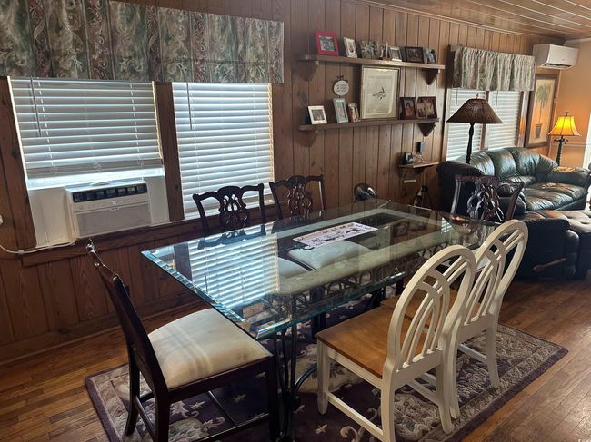 Dining area featuring a wall mounted AC, hardwood / wood-style floors, wooden walls, and cooling unit | Image 12