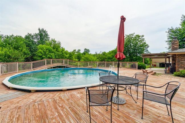 View of pool featuring a wooden deck | Image 37