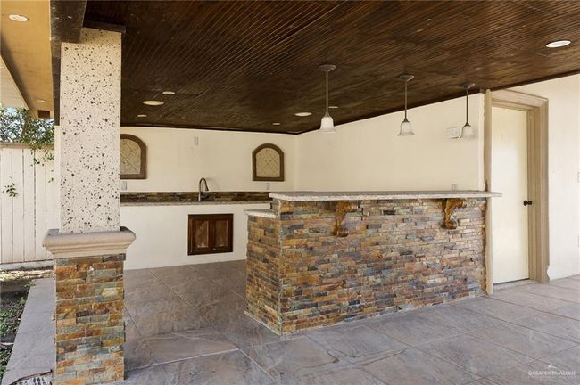 Bar featuring wooden ceiling, pendant lighting, and sink | Image 14