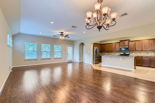Kitchen with appliances with stainless steel finishes, open floor plan, arched walkways, decorative backsplash, and wood finished floors | Image 9