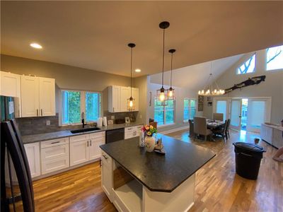 Kitchen with black appliances, white cabinetry, and a healthy amount of sunlight | Image 3