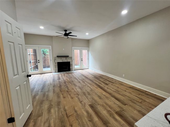 Unfurnished living room with french doors, wood finished floors, and recessed lighting | Image 9