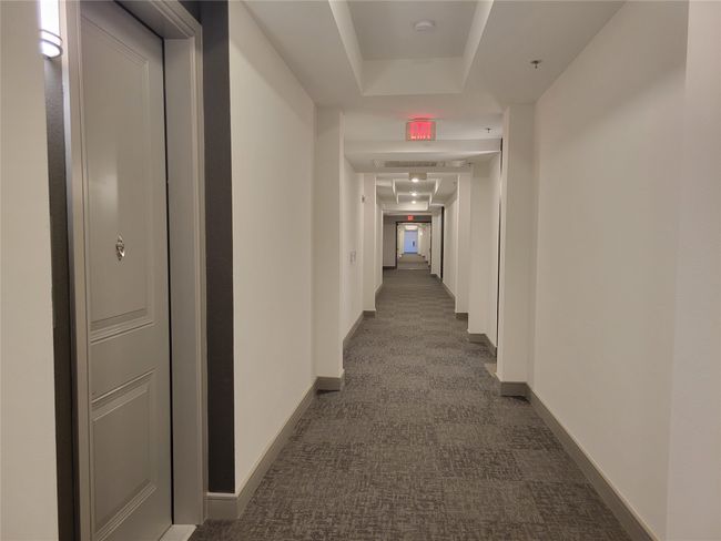 Hallway featuring baseboards and a tray ceiling | Image 17