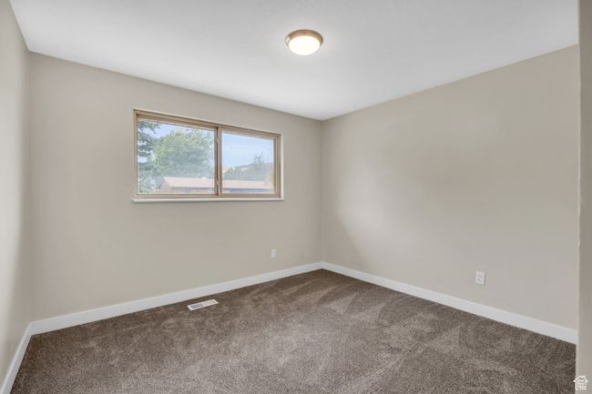 Spare room featuring dark colored carpet, visible vents, and baseboards | Image 17