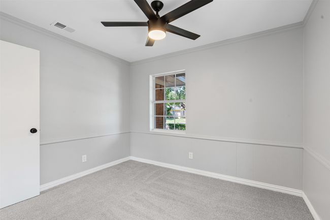 Carpeted empty room with a ceiling fan and ornamental molding | Image 18
