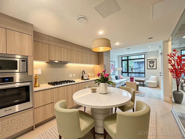Kitchen featuring stainless steel appliances, light brown cabinetry, open floor plan, modern cabinets, and light countertops | Image 19