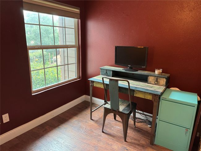 Home office featuring healthy amount of natural light, wood finished floors, and a textured wall | Image 10
