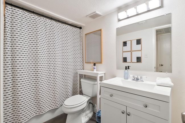 Bathroom featuring a textured ceiling, a shower with curtain, and vanity | Image 17