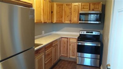 Kitchen featuring appliances with stainless steel finishes and dark hardwood / wood-style floors | Image 3