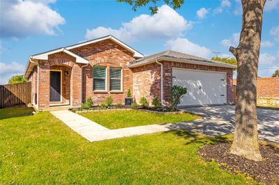 Ranch-style home with a front yard and a garage | Image 2