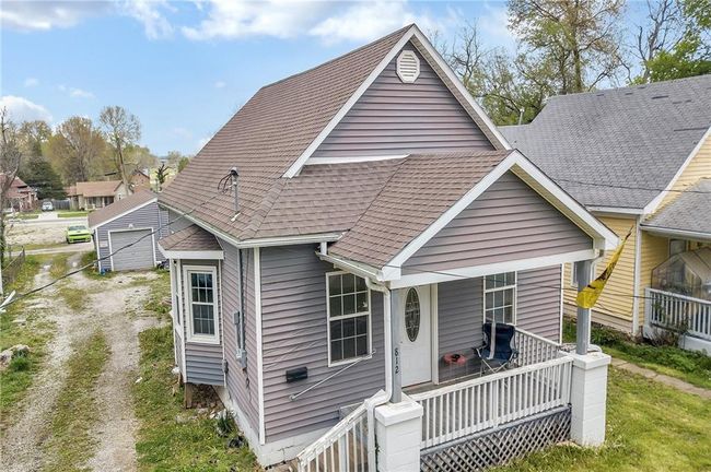 Rear view of property with a porch and a shingled roof | Image 8