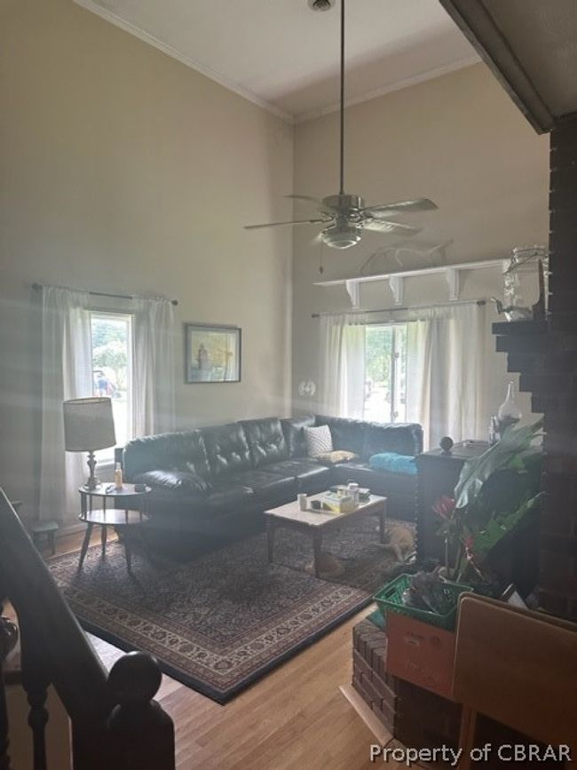 Living room with a healthy amount of sunlight, ornamental molding, hardwood / wood-style floors, and ceiling fan | Image 10