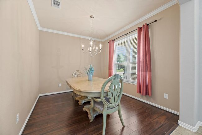 Fanciful dinners or a casual romantic dinner for two are elevated in the formal dining room. Thick white crown molding and the delicate light fixture add just the right amount of opulence for a chic dining experience. | Image 20