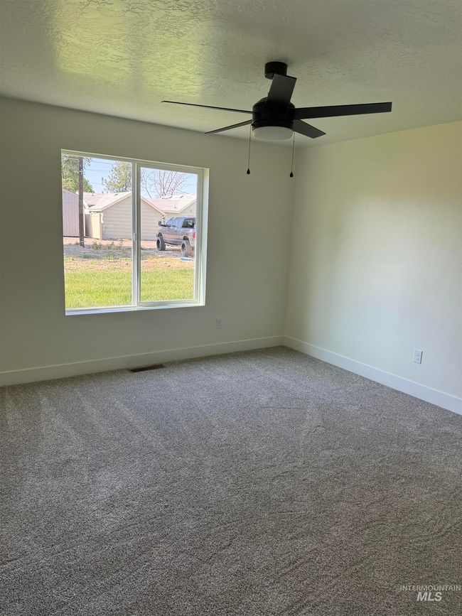 Spare room featuring ceiling fan, a textured ceiling, and carpet floors | Image 8