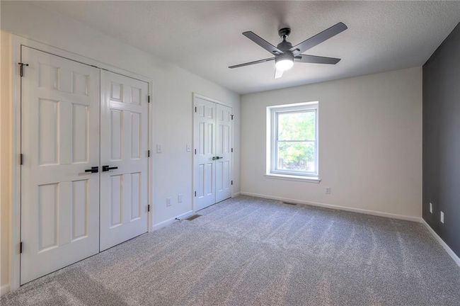 Unfurnished bedroom featuring multiple closets, carpet, and a ceiling fan | Image 10