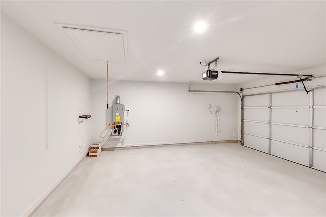 Garage featuring a garage door opener, recessed lighting, and water heater | Image 28