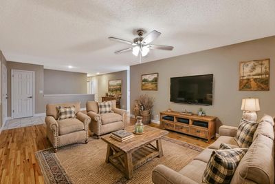 Living room featuring light wood-type flooring, ceiling fan, and a textured ceiling | Image 3