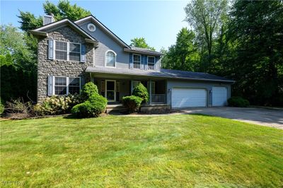 Colonial inspired home featuring a porch, a garage, and a front yard | Image 2