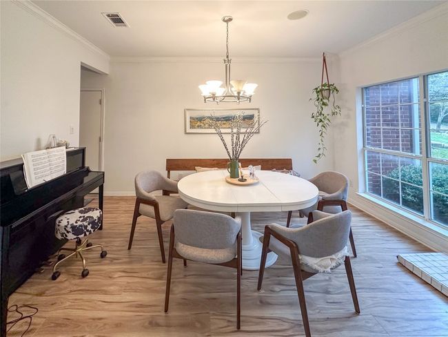 Dining space featuring a chandelier, crown molding, and light wood-style floors | Image 4