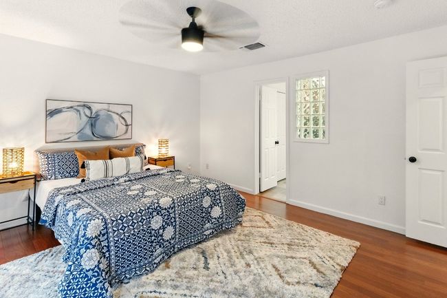 private primary suite is a true retreat with balcony access overlooking the backyard, refinished hardwood floors, and a luxurious en-suite bath. | Image 12