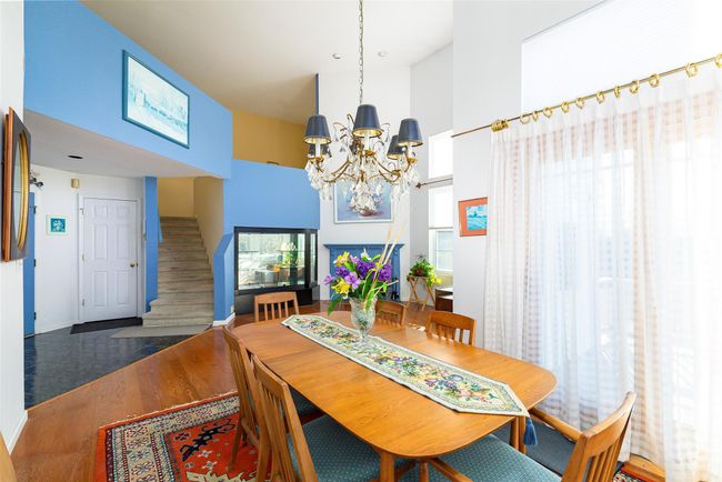 Dining space with a notable chandelier, a healthy amount of sunlight, and wood-type flooring. SGD to deck | Image 8