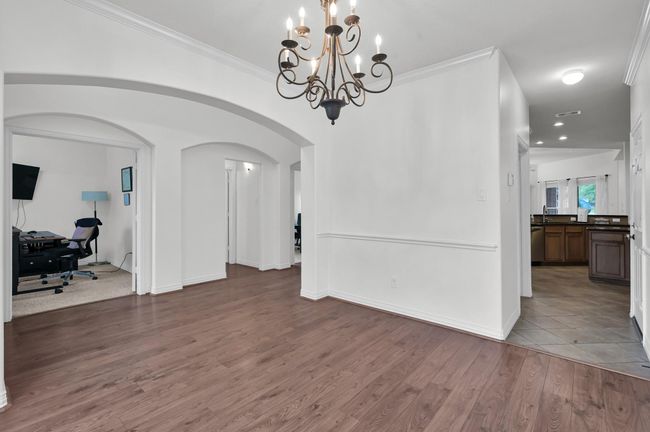 Crown molding, chair rail molding, and arched openings add architectural charm and give this home a stately feel. | Image 10