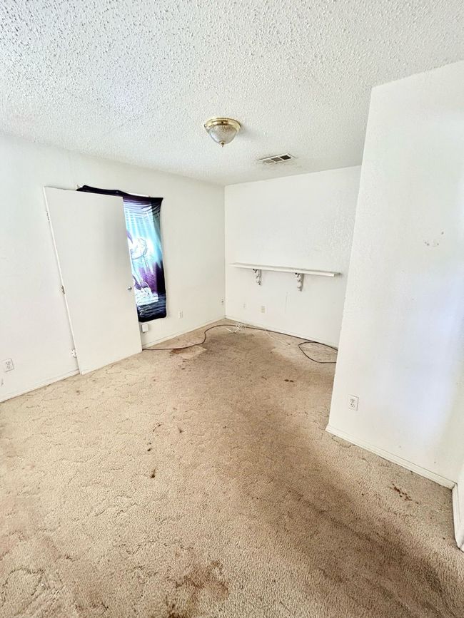 Carpeted empty room with a textured ceiling | Image 12