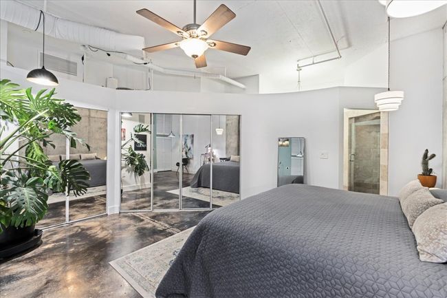 Bedroom with concrete floors, a high ceiling, and multiple closets | Image 23