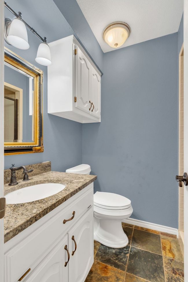 Bathroom featuring stone tile floors, vanity, and a shower | Image 22
