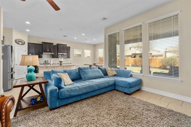 Living room with light tile patterned flooring, a ceiling fan, baseboards, visible vents, and recessed lighting | Image 5