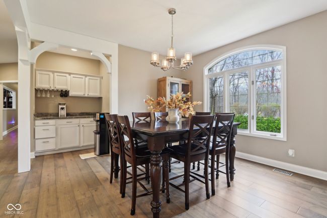dining space featuring baseboards, visible vents, light wood-style flooring, and a chandelier | Image 7