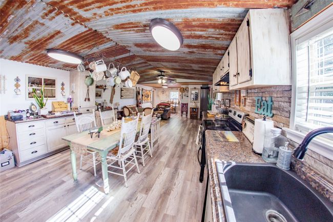 Kitchen with vaulted ceiling, light hardwood / wood-style flooring, ceiling fan, and sink | Image 5