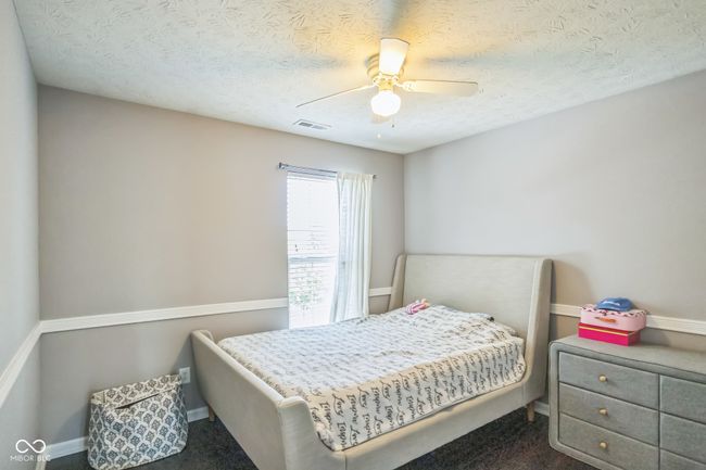 carpeted bedroom featuring a ceiling fan and a textured ceiling | Image 19